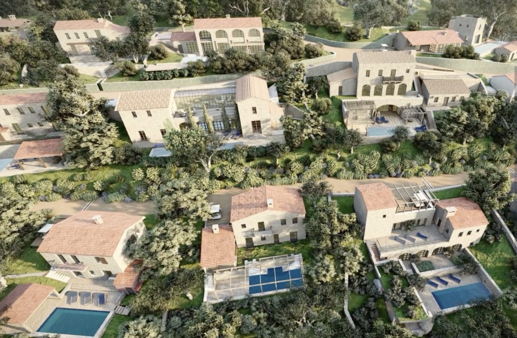 THE VILLAGE · aerial view of fourteen old-stone villas scattered across a wooded hillside in Southern France